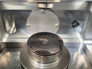 Vacuum tribometer rotary stage for testing friction of lubricated surfaces and vacuum-compatible greases.